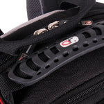 Close-up of a black camera gear bag showing a textured black webbing zipper, silver metal zipper pulls, and a black plastic ventilation-style handle with a red and white logo.
