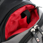 Close-up of an open gray and black backpack showing a bright red interior lining with a black handle and silver zipper pulls.