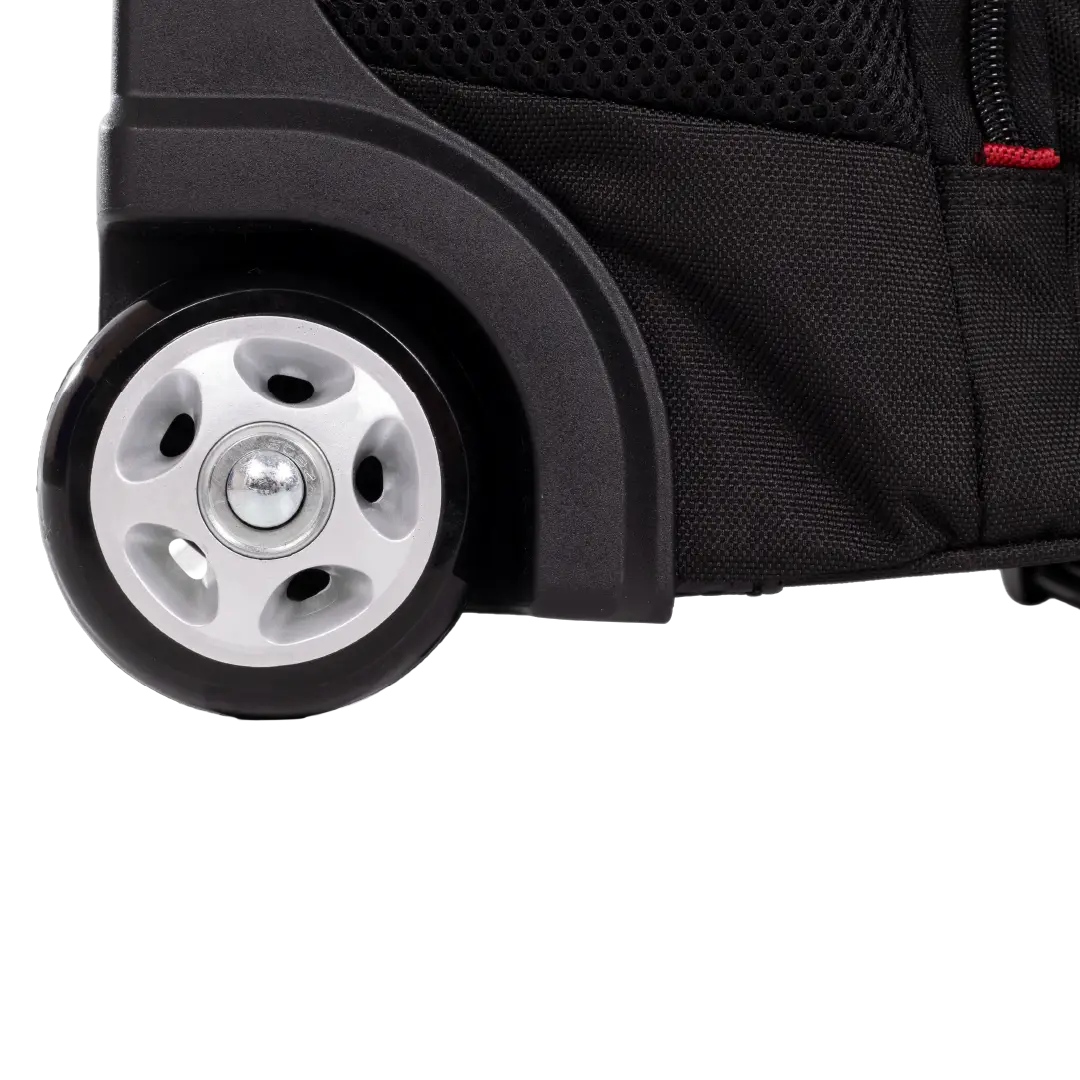 Close-up of a black wheeled suitcase or bag showing a black wheel, silver hubcap, black plastic wheel housing, and textured black fabric side panel on a white background.