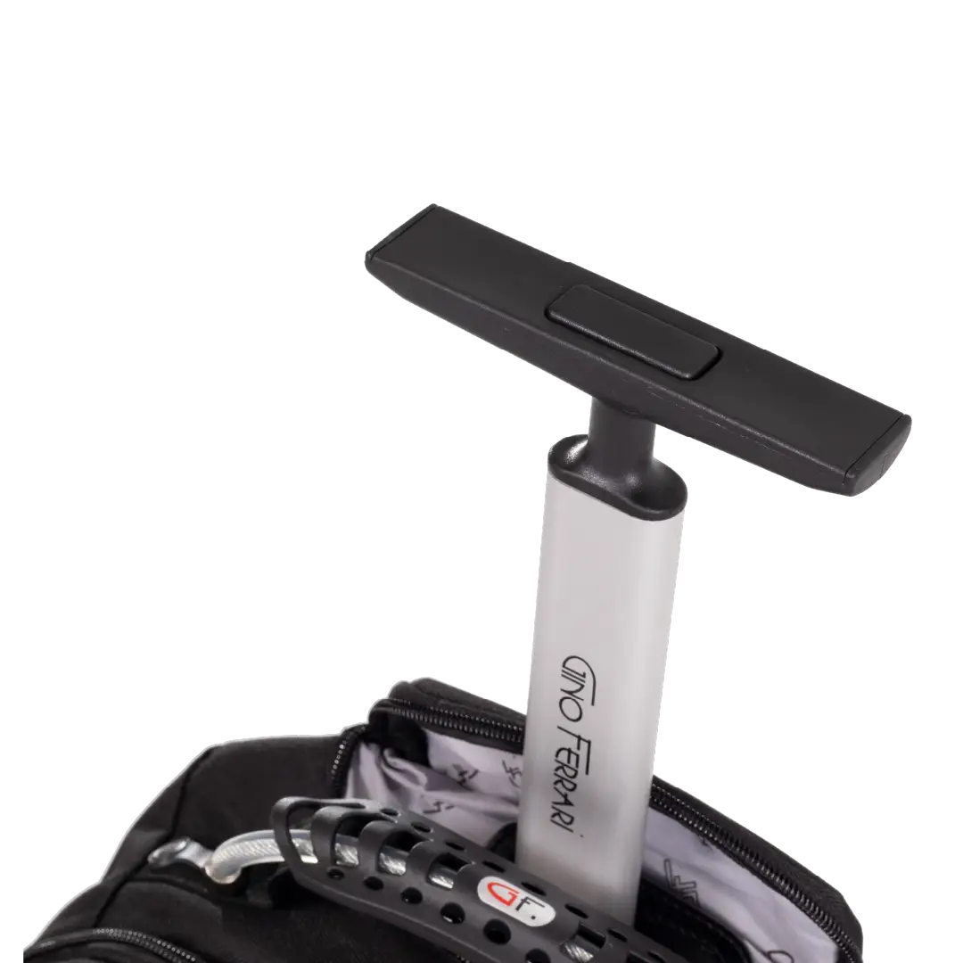Close-up of a rolling suitcase handle with a black T-shaped head and a silver-and-black shaft, partially inserted into an open suitcase on a white background.