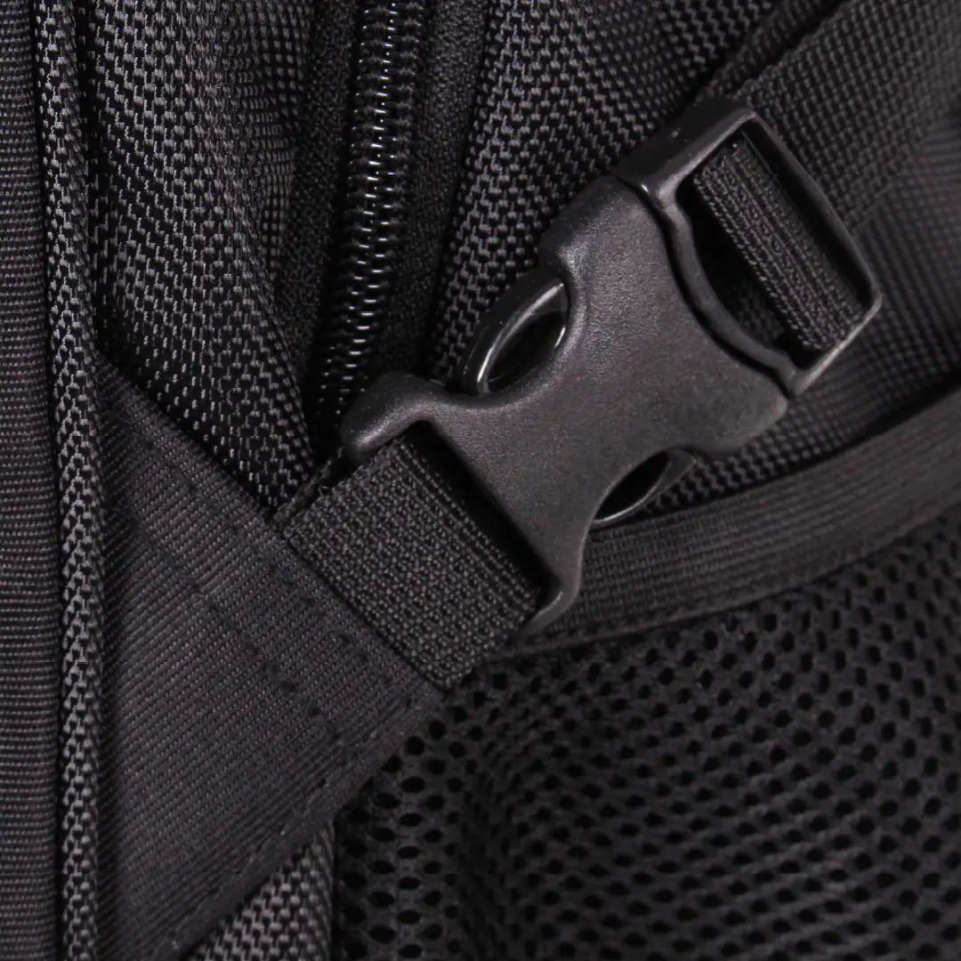 Close-up detail of a black nylon backpack showing a zipper, webbing strap, and plastic quick-release buckle.