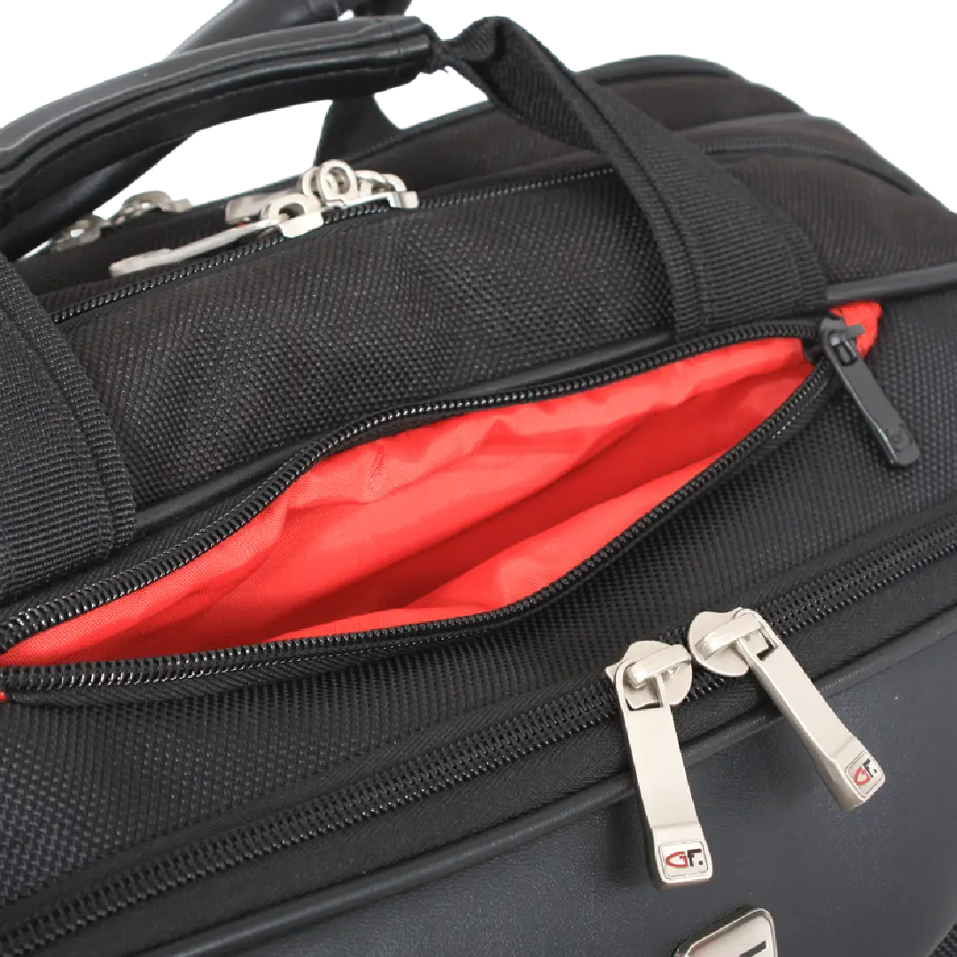 Close-up of a black duffel bag with an open top zipper revealing a bright red interior lining, plus silver metal zipper pulls on a white background.