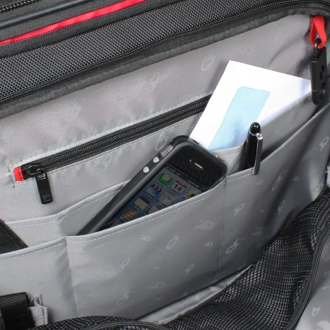 Close-up of a gray and black backpack interior showing a front zip pocket holding a smartphone, a pen, and a folded white paper or document.