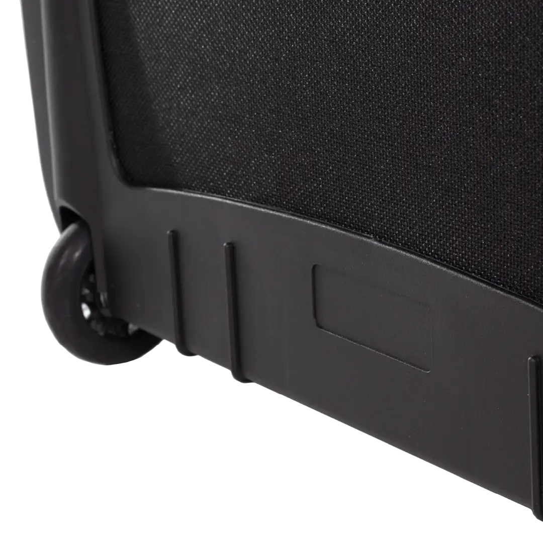 Close-up of the lower corner of a black wheeled suitcase, showing a black fabric side panel, black plastic base trim, and a black caster wheel on a white background.
