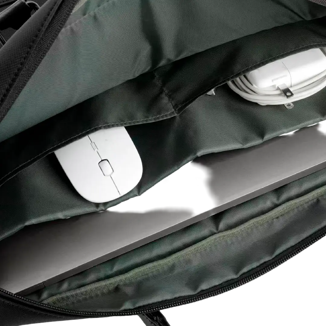 Close-up of a dark green laptop bag's interior showing a white mouse, a gray laptop, and white earbud charging cases in the compartments.