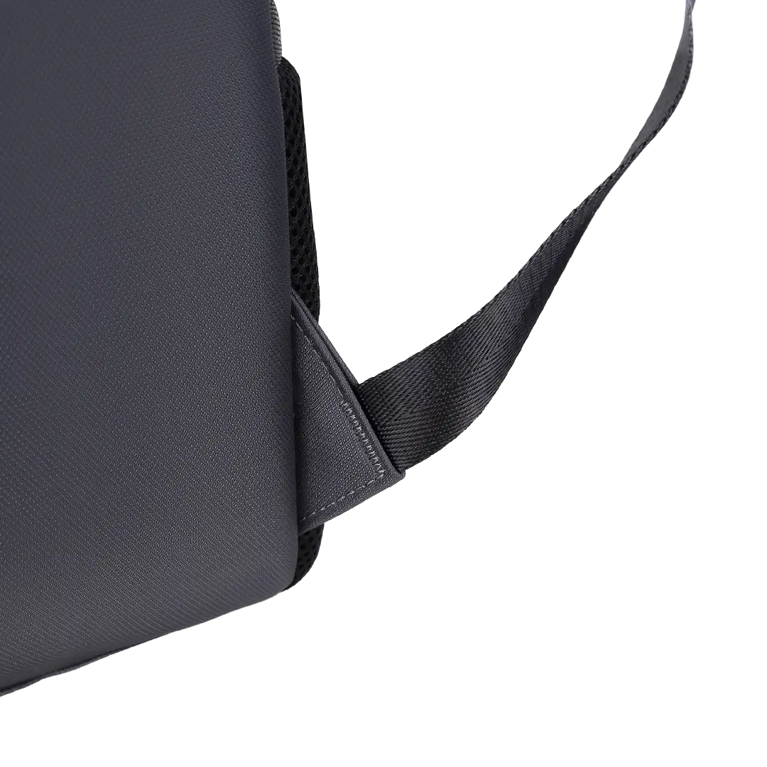Close-up of a black textured bag with a black webbing strap attached, shown on a plain white background.