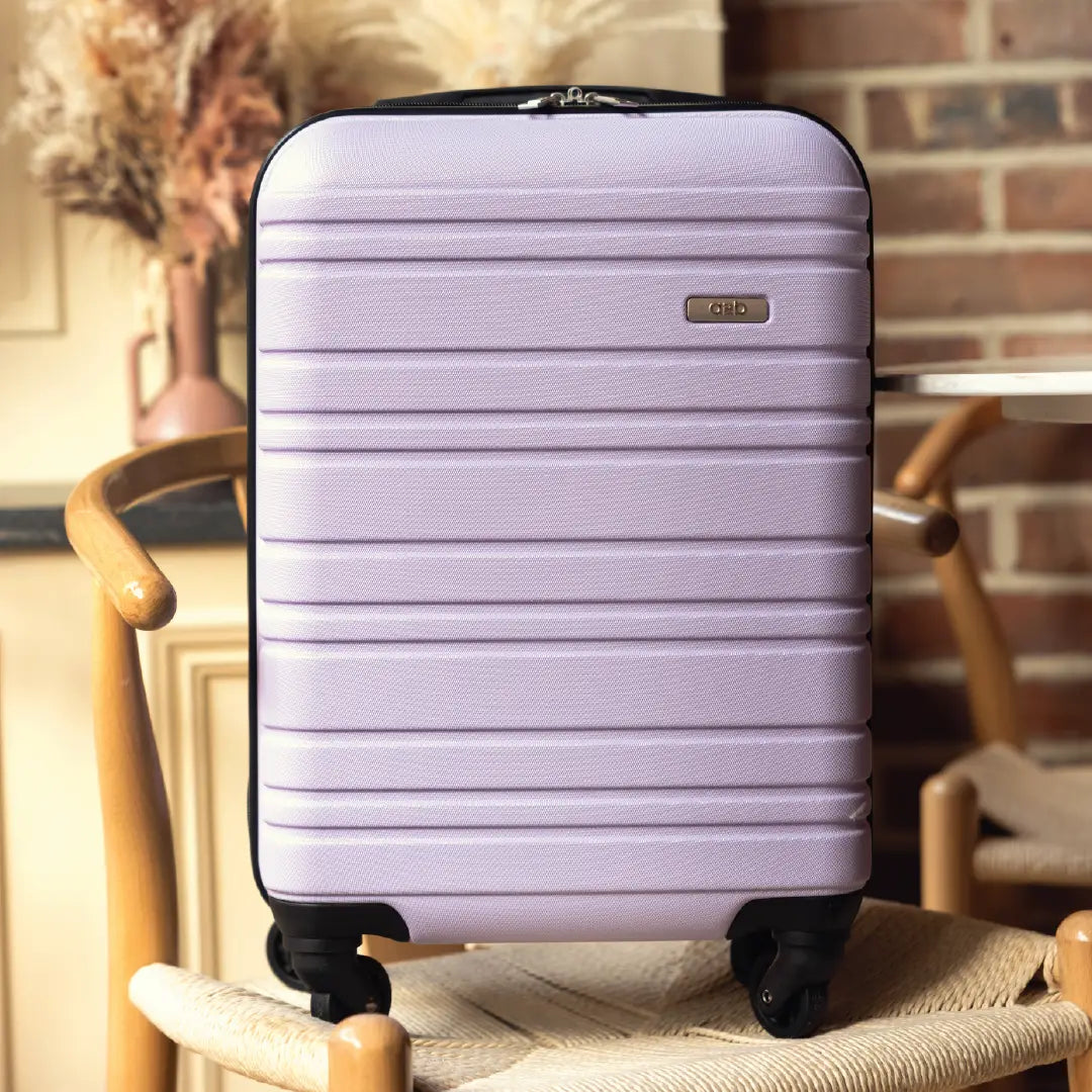 Purple suitcase on a chair with a blurred indoor background
