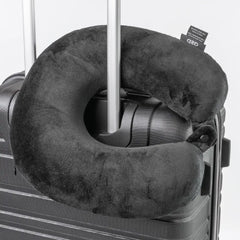 Gray travel neck pillow on a suitcase with a white background
