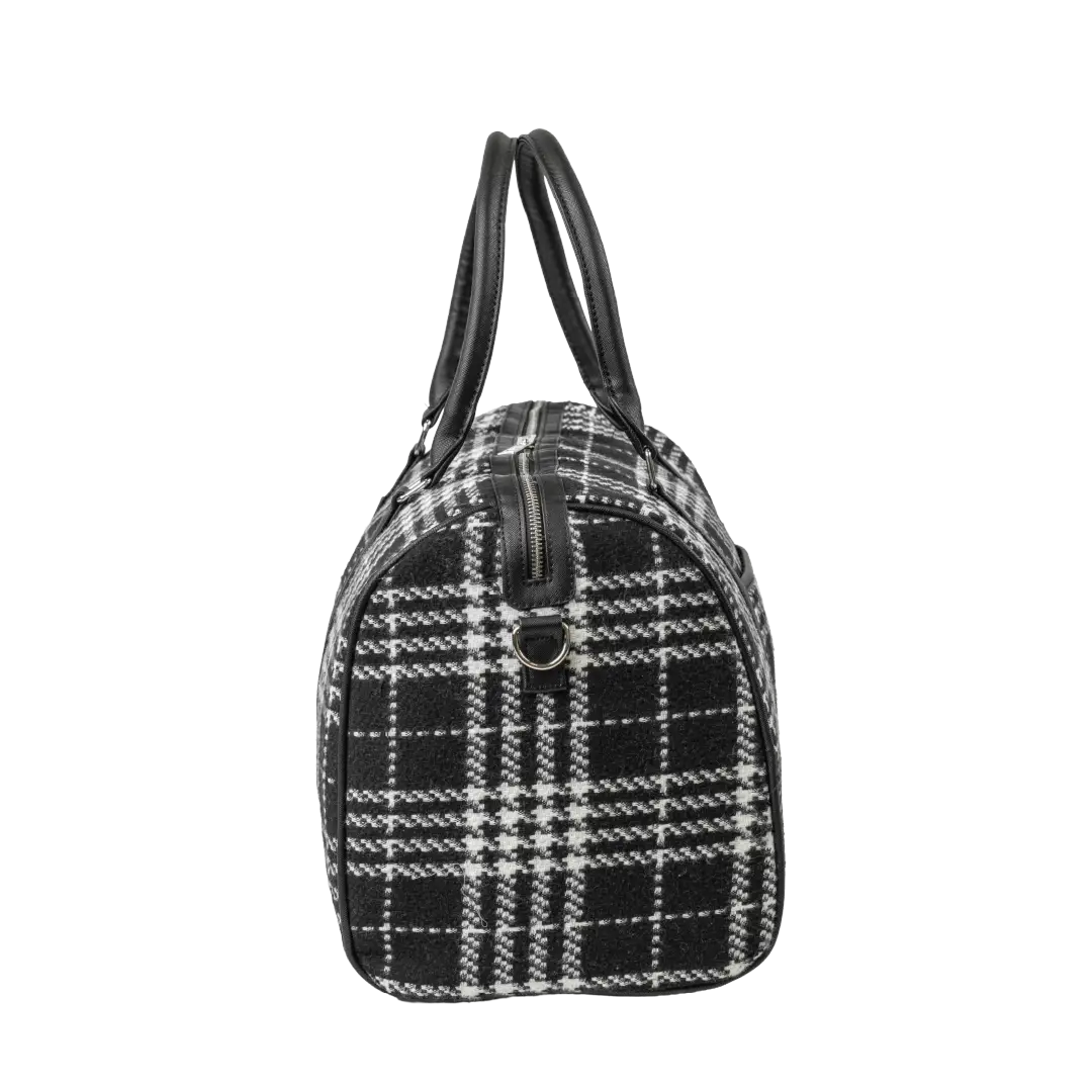 Black and white checkered handbag with leather handles on a white background