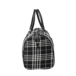 Black and white checkered handbag with leather handles on a white background