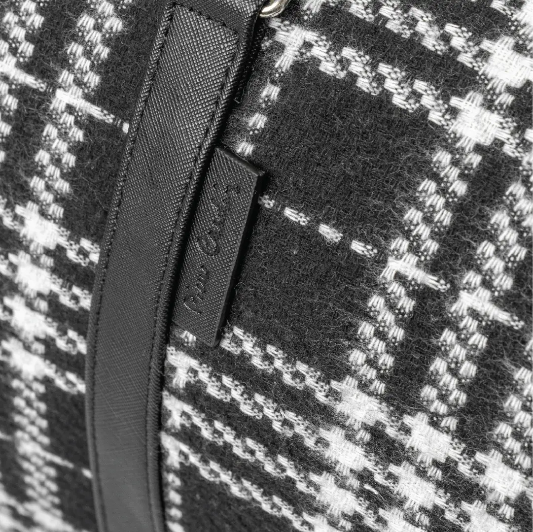Close-up of a black and white checkered fabric with a zipper detail.