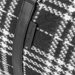 Close-up of a black and white checkered fabric with a zipper detail.