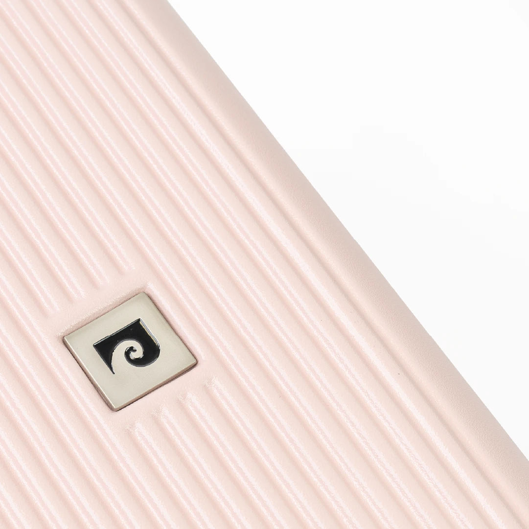 Close up of a pink ribbed suitcase with brand logo.