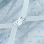 Suticase interior with strap and buckle and brand logo.