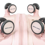 Pink suitcase with 'Pierre Cardin' wheels on a white background