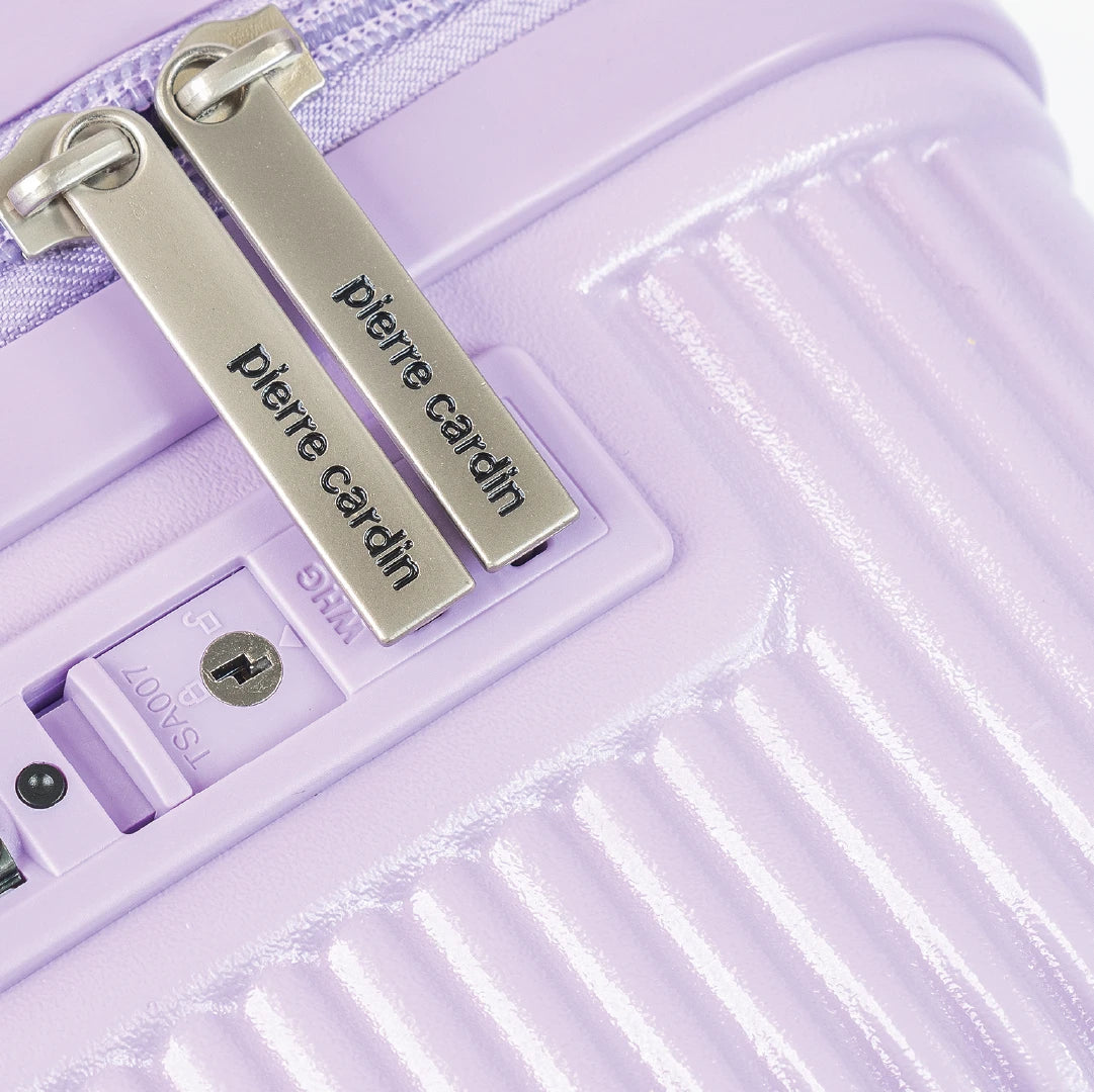 Close-up of a purple suitcase with 'Pierre Cardin' branding on a white background