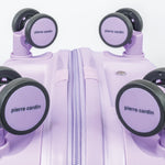 Purple suitcase with wheels and 'Pierre Cardin' branding on a white background