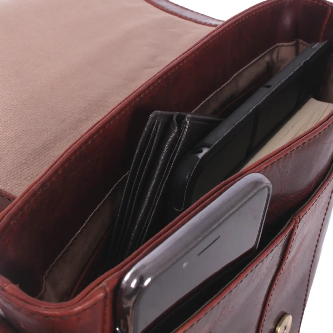 Close-up of an open brown leather bag showing interior compartments with cards, a black folio, and a smartphone inside.
