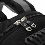 Close-up of a black textured nylon bag with dual silver metal zipper pulls featuring a black square logo.