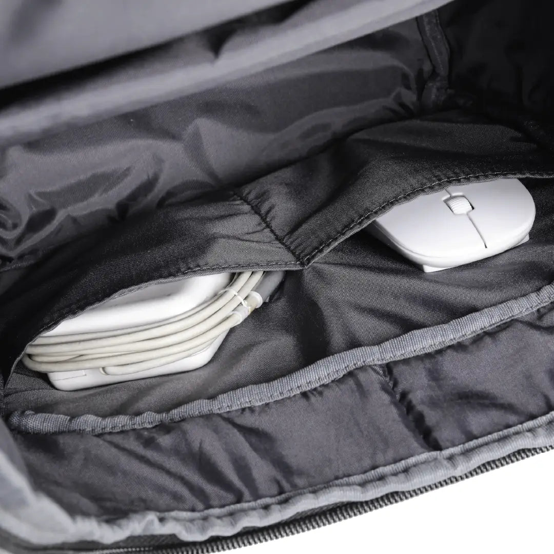 Black backpack with electronic devices inside showing the compartments within the backpack.
