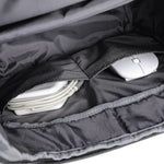 Black backpack with electronic devices inside showing the compartments within the backpack.