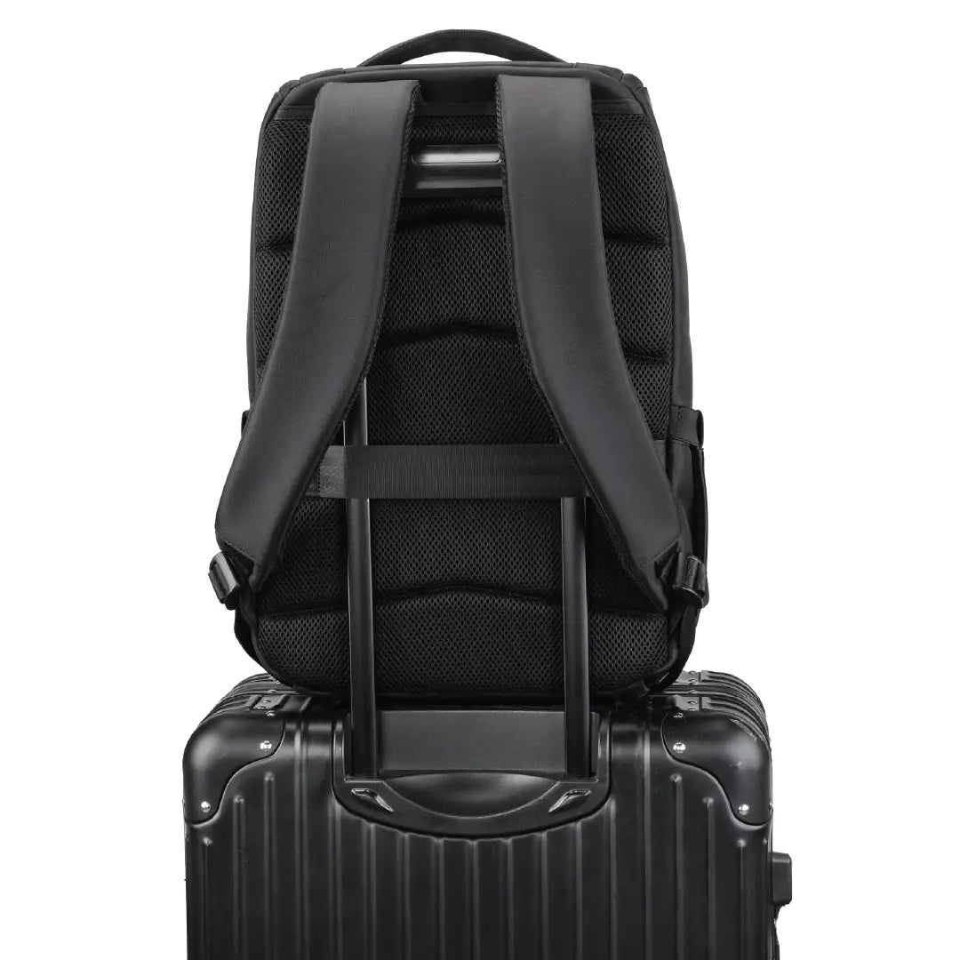 Black backpack shown from the back, resting on top of a black hard-shell rolling suitcase against a plain white background.