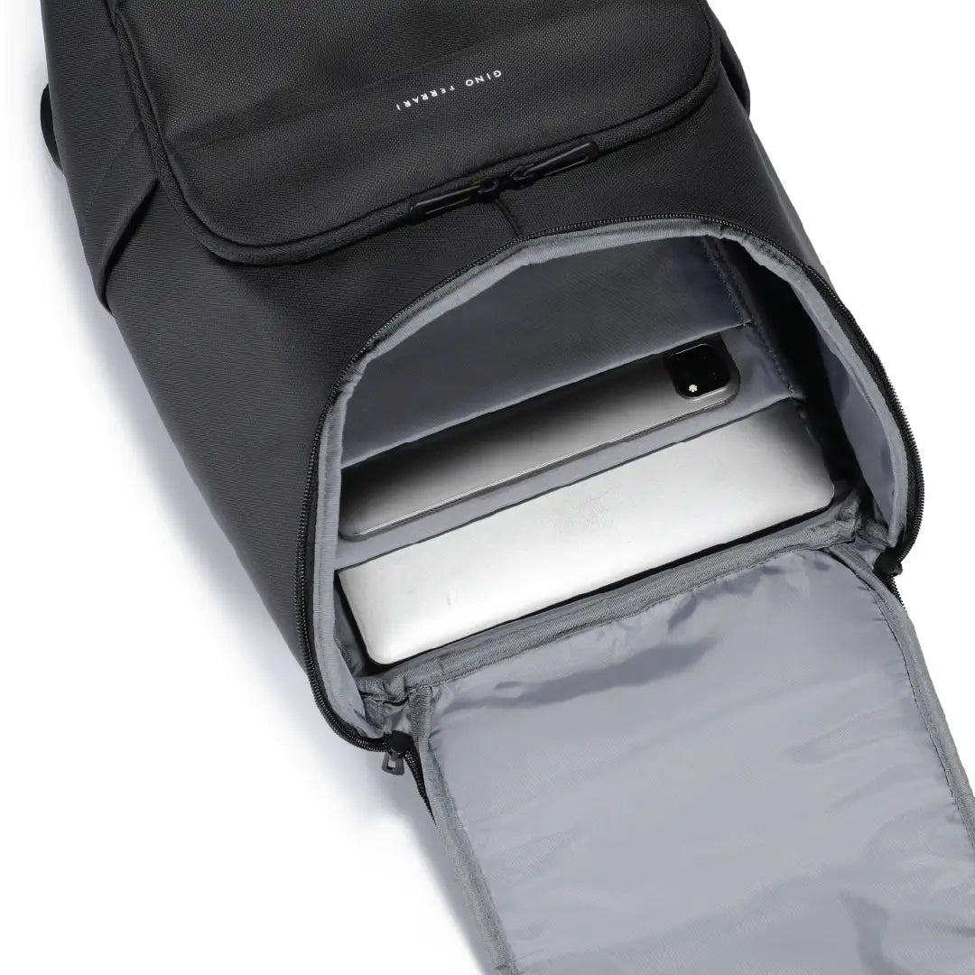 A black backpack shown open, revealing a silver laptop inside. The backpack has a front zippered pocket with the brand name 'Gino Ferrari' embroidered onto the backpack.