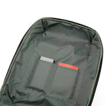 Close-up of the interior of a dark olive green backpack, showing a zippered compartment with two slip pockets holding a gray card and an orange card.