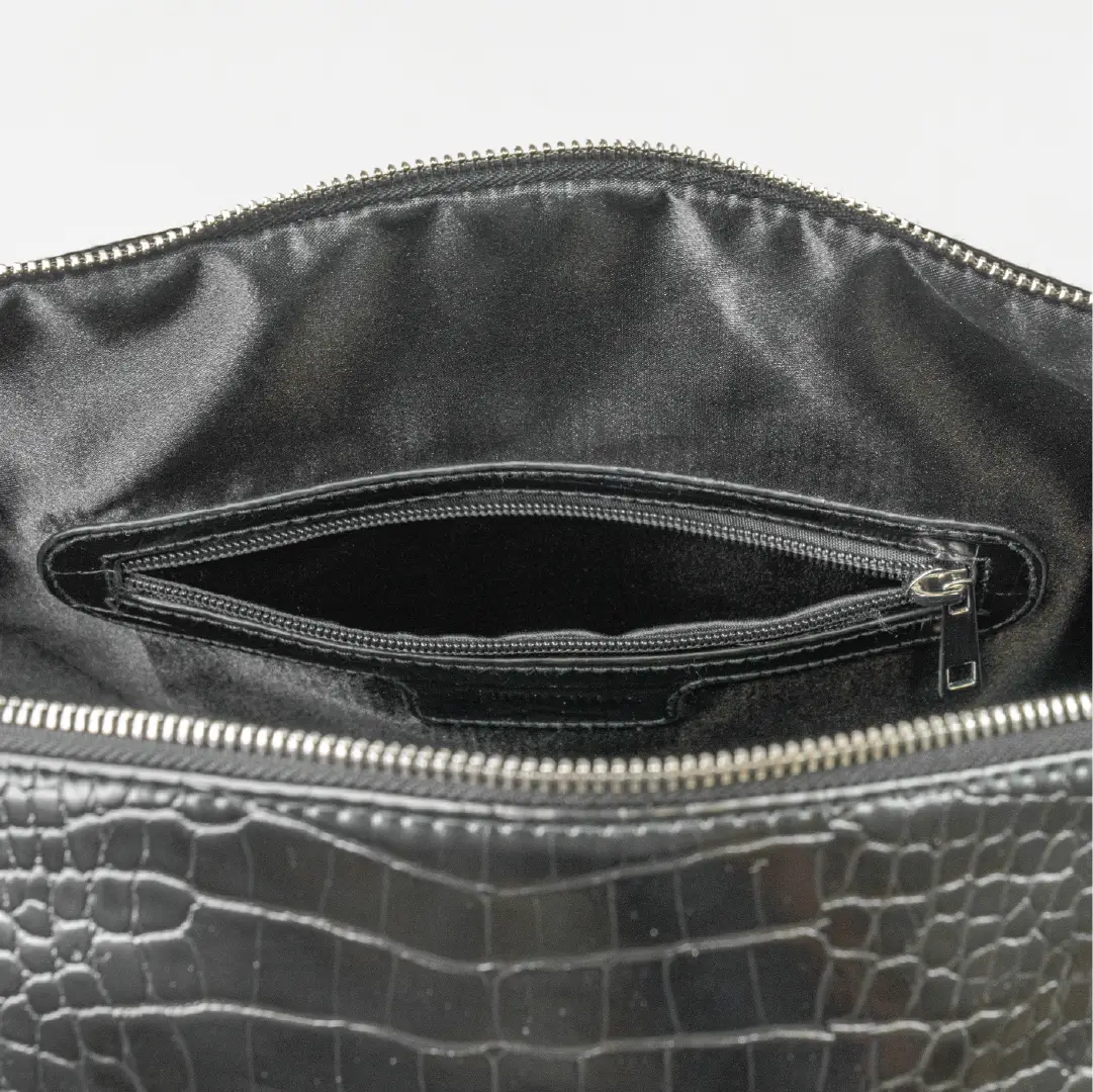 Leather-look textured bag with a pocket inside, handles and a silver zip with branding on it.