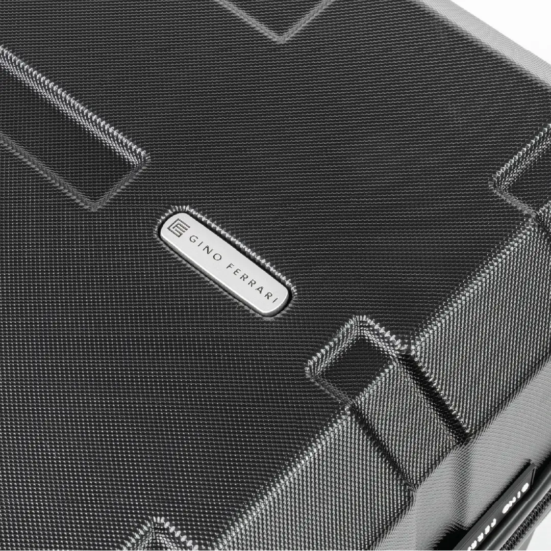 Close-up of a textured black surface with a brand logo in the center.