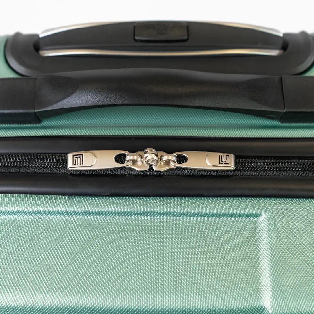 Close-up of a green suitcase handle and zipper area