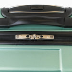Close-up of a green suitcase handle and zipper area