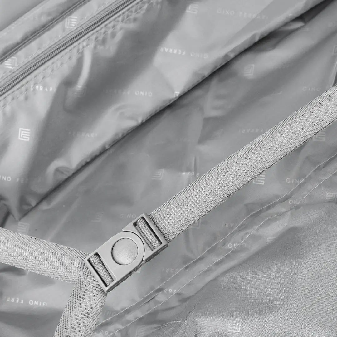 Close-up of a suitcase with a strap and visible branding.