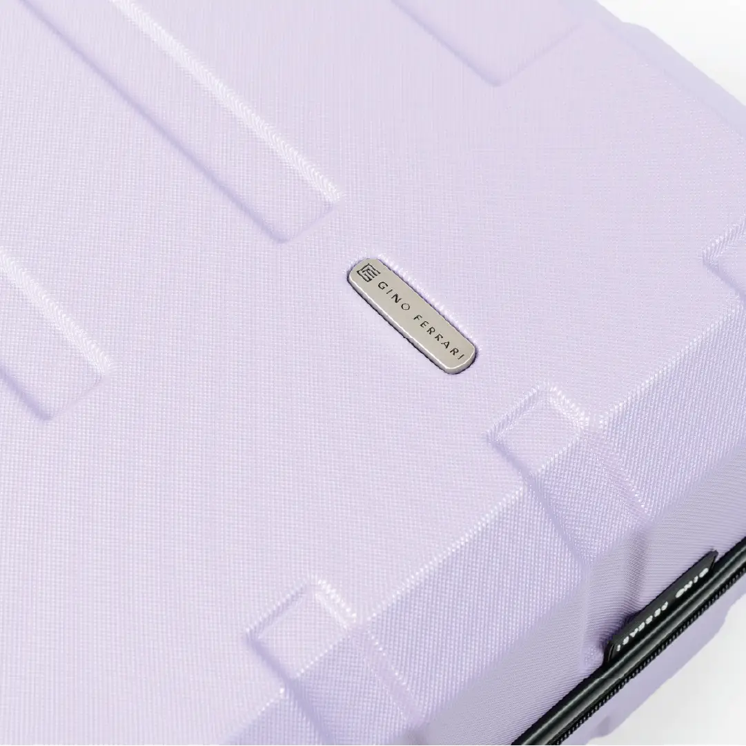 Close-up of a light purple suitcase with a brand logo on a white background