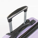 Close-up of a suitcase handle on a light purple suitcase with a white background