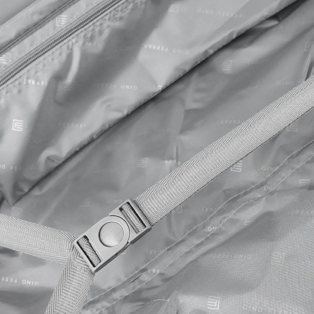 Close-up of a gray bag with a strap and visible branding.