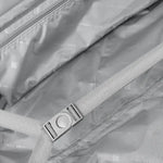 Close-up of a suitcase with a strap and buckle, featuring the brand.