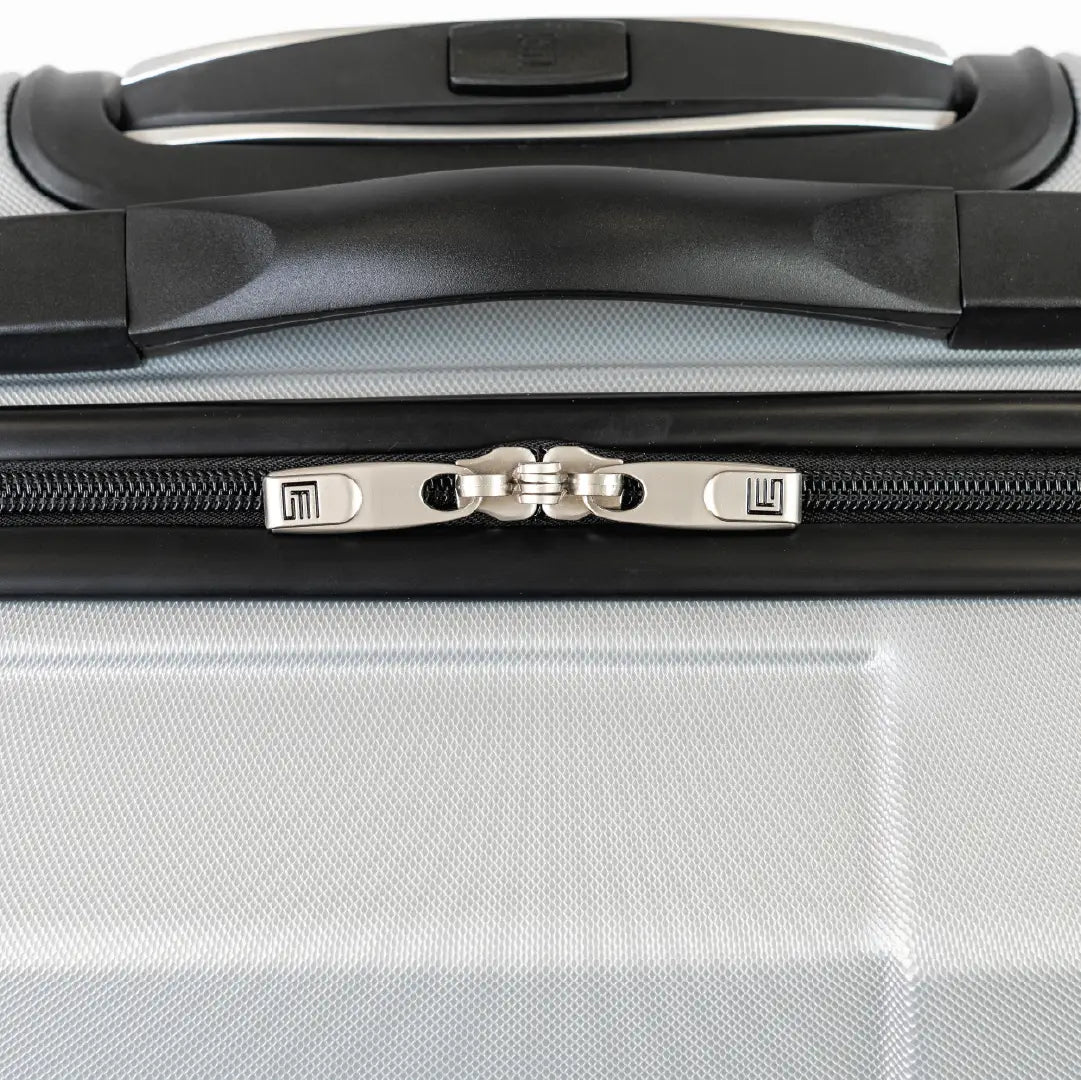 Close-up of a suitcase handle and zipper on a silver suitcase