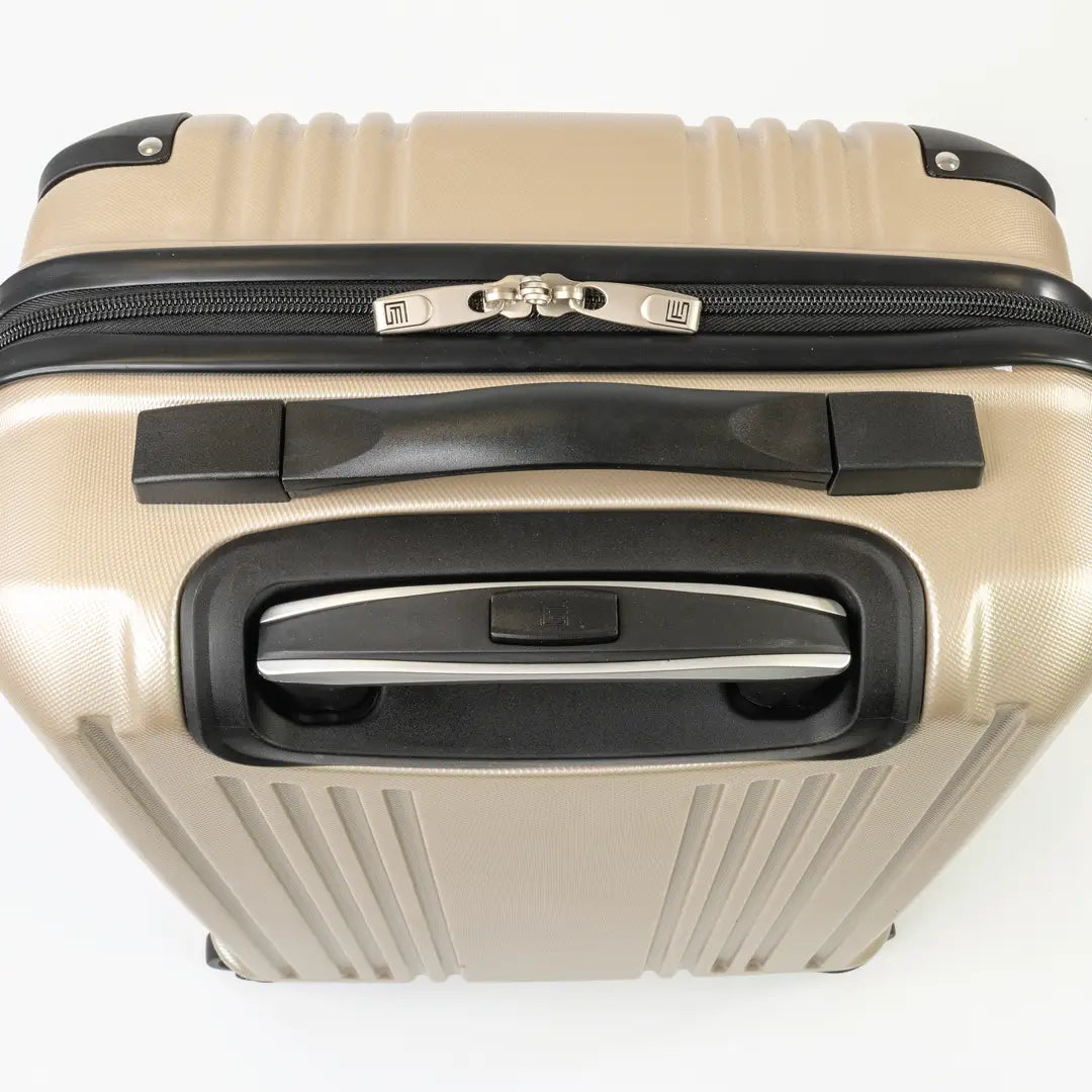 Gold hard-shell suitcase with black accents and a zip.