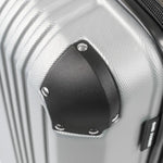 Close-up of a silver hard-shell suitcase with black corner.