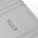 Close-up of a silver hard-shell suitcase with the brand logo 'Gino Ferrari' visible.