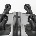 Close-up of the bottom of a silver suitcase showcasing the wheels and zip.