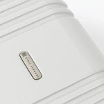 Close-up of a silver hard-shell suitcase with a visible brand logo 'Gino Ferrari'.