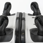 Close-up of the bottom of a silver suitcase showcasing the wheels and zip.