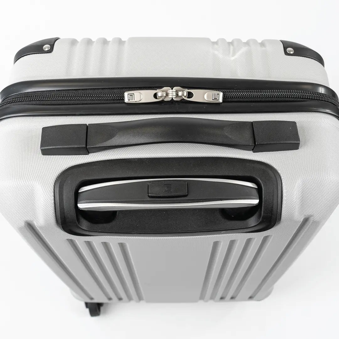 Close-up of a silver hard-shell suitcase with black accents.