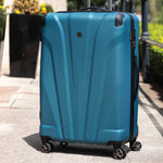 Blue suitcase with wheels on a pavement