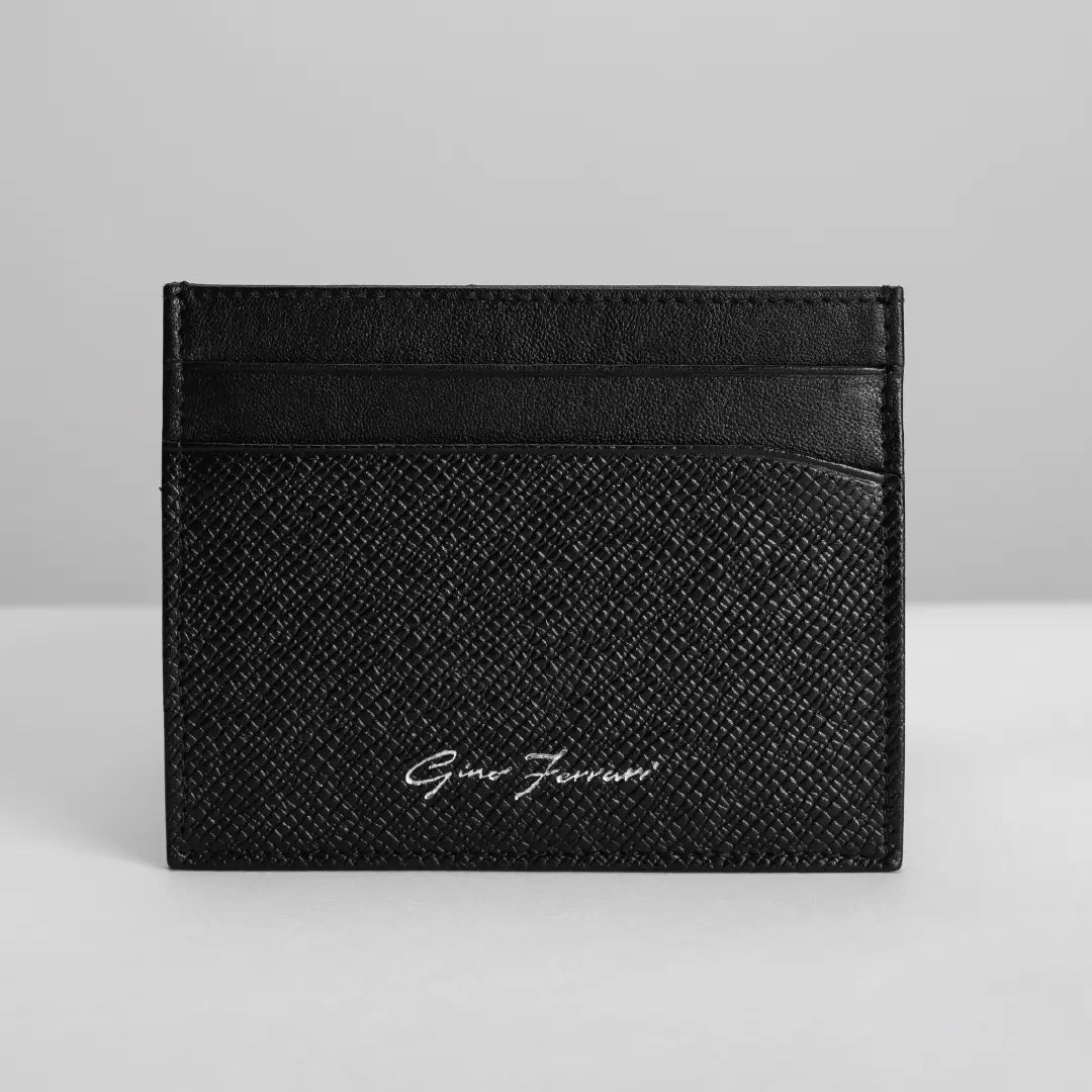 A black textured leather card holder wallet with a black leather stripe at the top and a silver 'Gino Ferraro' logo on the front, set against a light gray background.