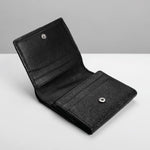 A black leather bi-fold wallet shown open, featuring a textured grain pattern on the front pocket and silver-tone snap buttons, set against a clean gray and white background.