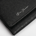 A close-up of a black textured leather clutch or wallet with a silver-tone script logo reading 'Gino Ferrani' on a white background.