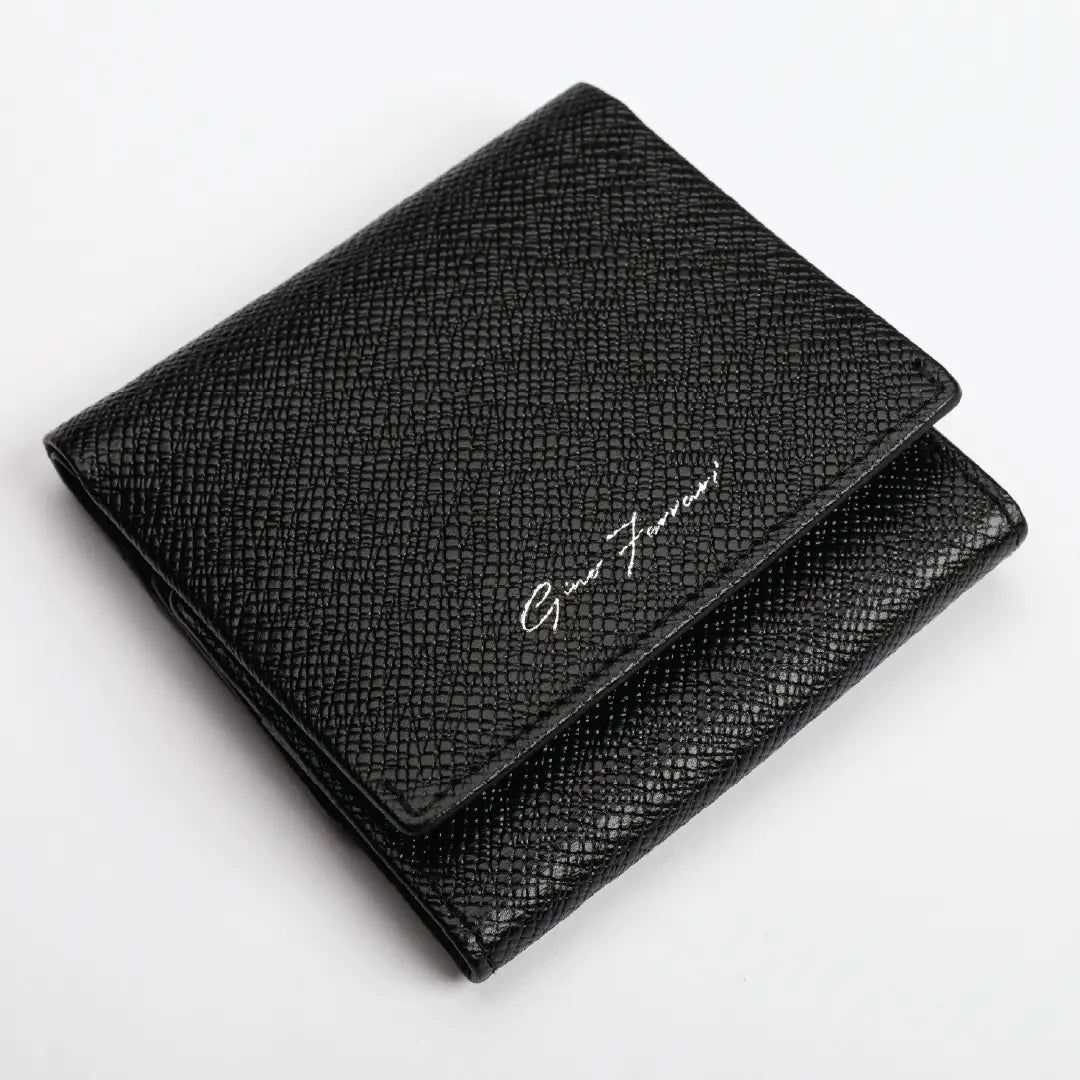 A black textured leather bifold wallet with a silver-tone script logo reading 'Gino Ferrari' on the front flap, shown on a clean white background.